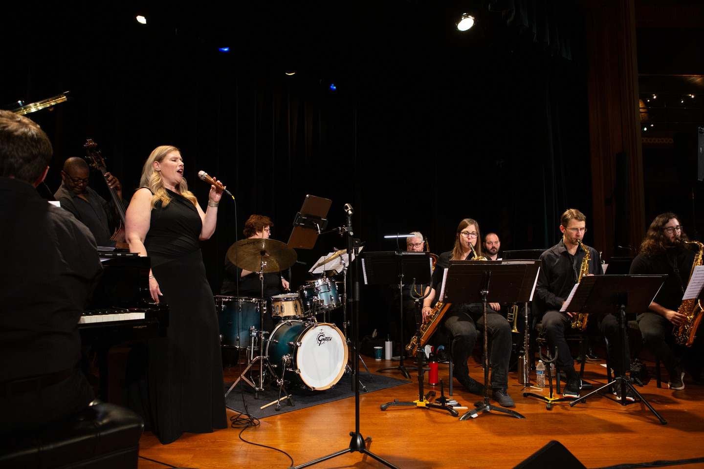 The vocalist singing at center stage with the full rhythm section and horns spread across the stage.